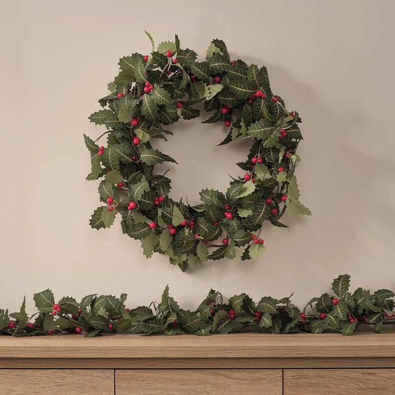 Weihnachtskranz und Weihnachtsgirlande mit Stechpalme und Beleuchtung