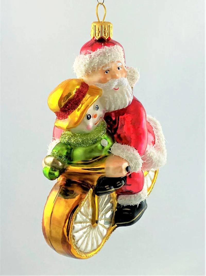 Weihnachtsmann und Schneemann fahren gemeinsam Fahrrad