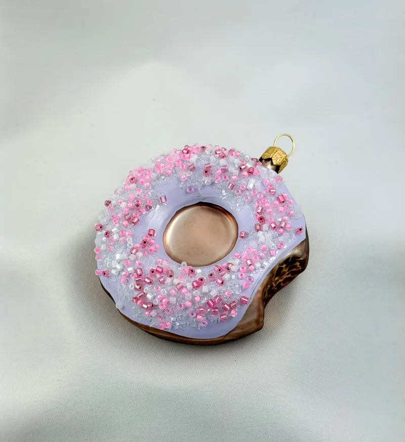 Donut mit lila Zuckerguss und pinken Streusseln
