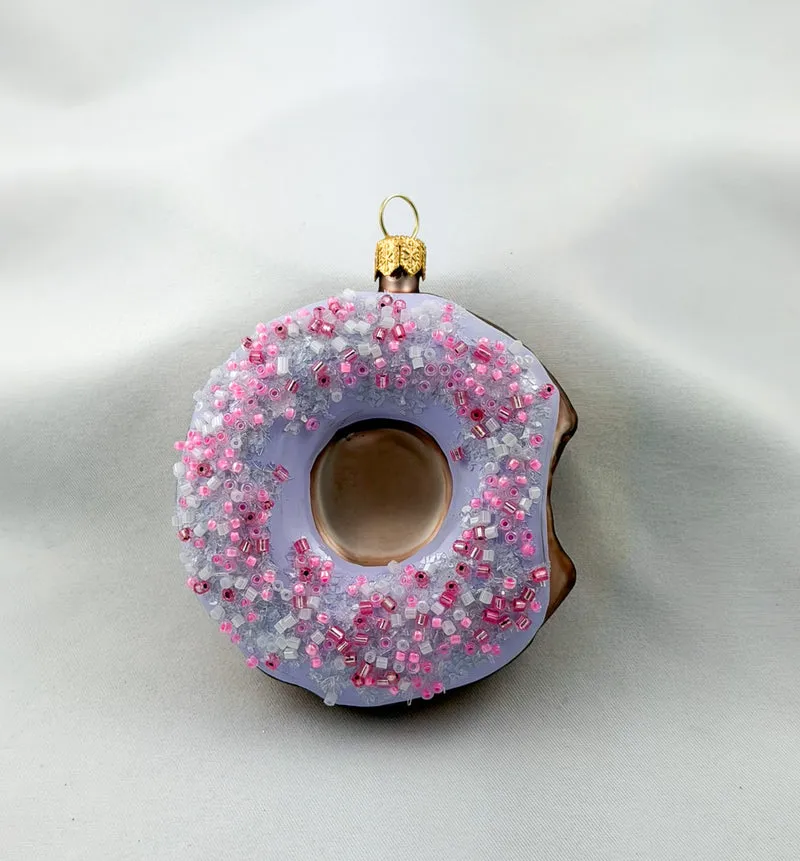 Donut mit lila Zuckerguss und pinken Streusseln