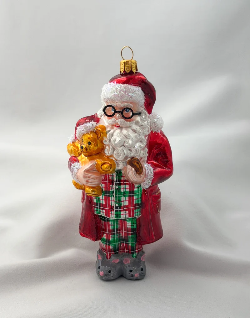 Santa hat es sich mit dem Teddy-Bär in Mäuse-Pantoffeln und Pyjama gemütlich gemacht