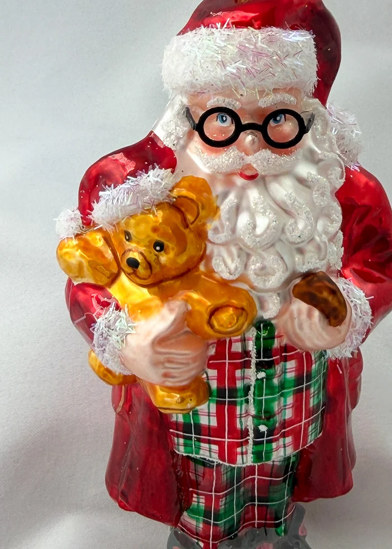 Santa hat es sich mit dem Teddy-Bär in Mäuse-Pantoffeln und Pyjama gemütlich gemacht