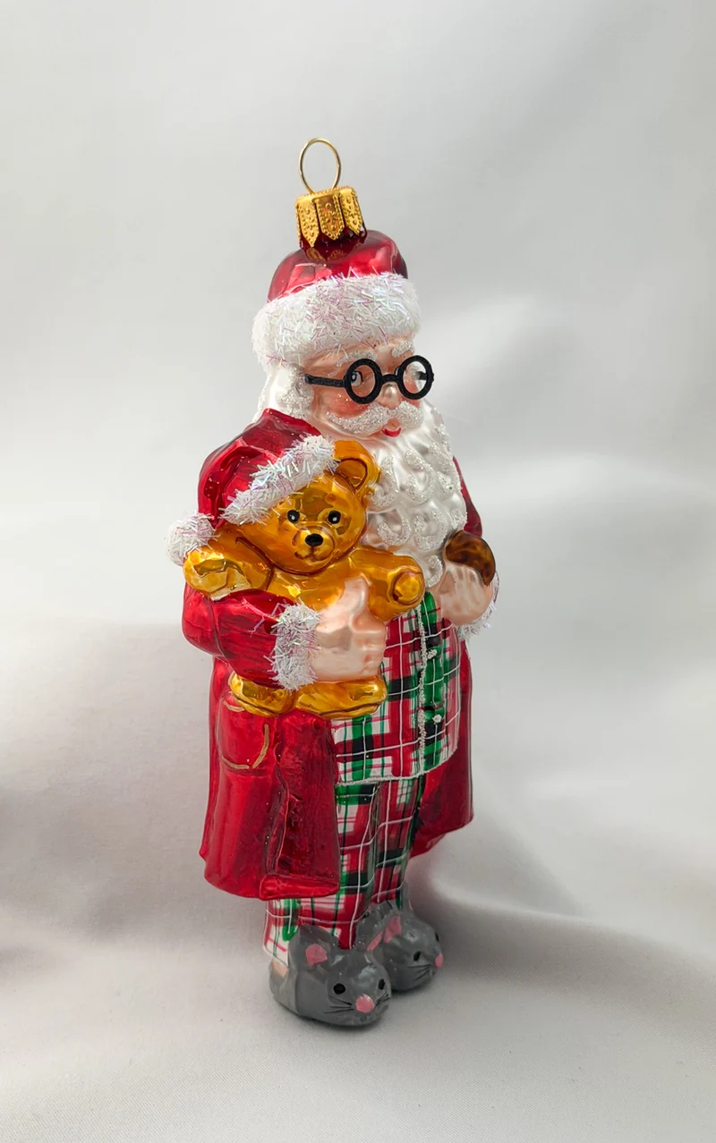 Santa hat es sich mit dem Teddy-Bär in Mäuse-Pantoffeln und Pyjama gemütlich gemacht