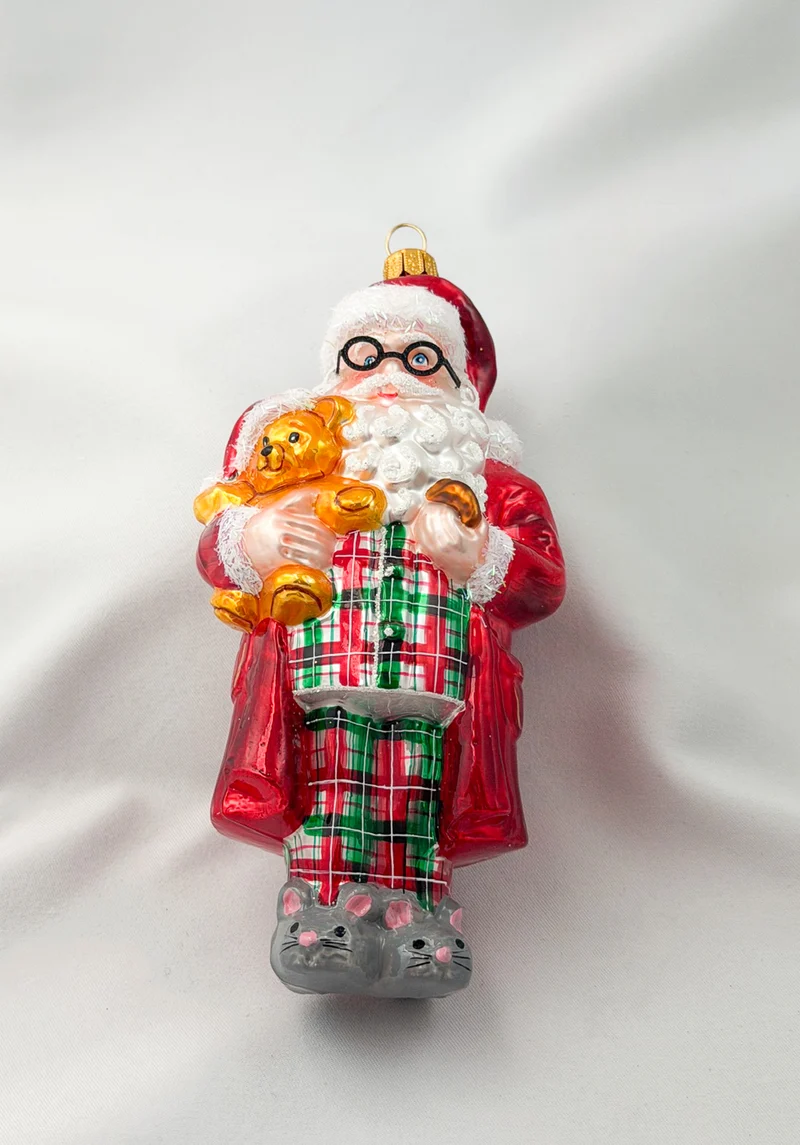 Santa hat es sich mit dem Teddy-Bär in Mäuse-Pantoffeln und Pyjama gemütlich gemacht