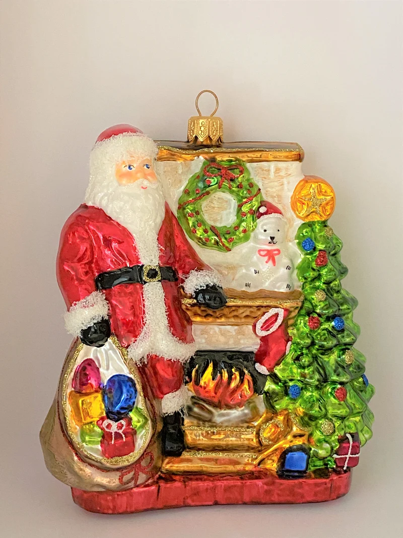 Santa Claus wärmt sich am Kaminfeuer auf