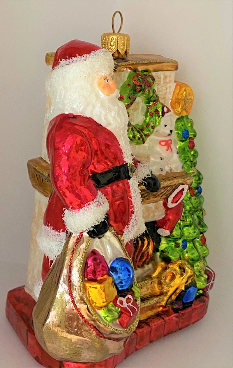 Santa Claus wärmt sich am Kaminfeuer auf