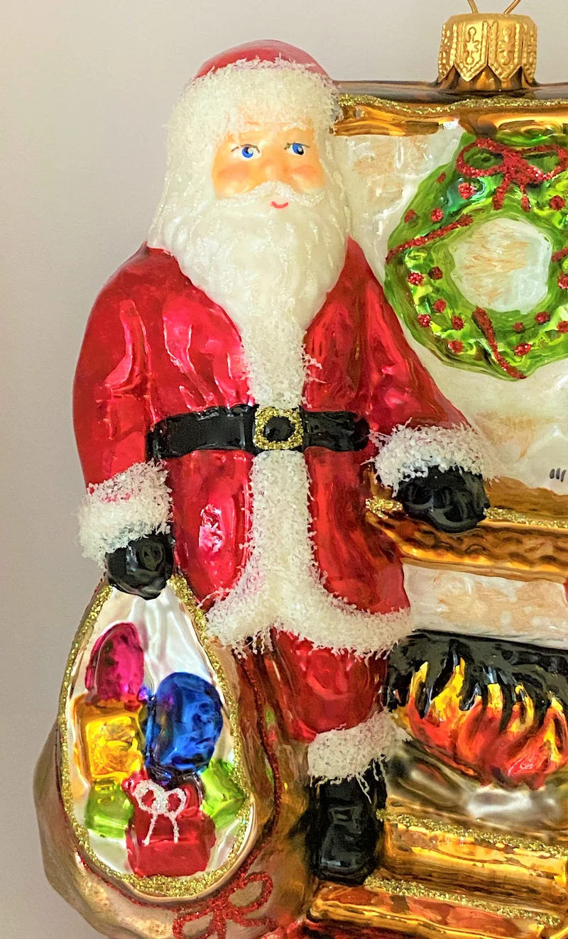 Santa Claus wärmt sich am Kaminfeuer auf