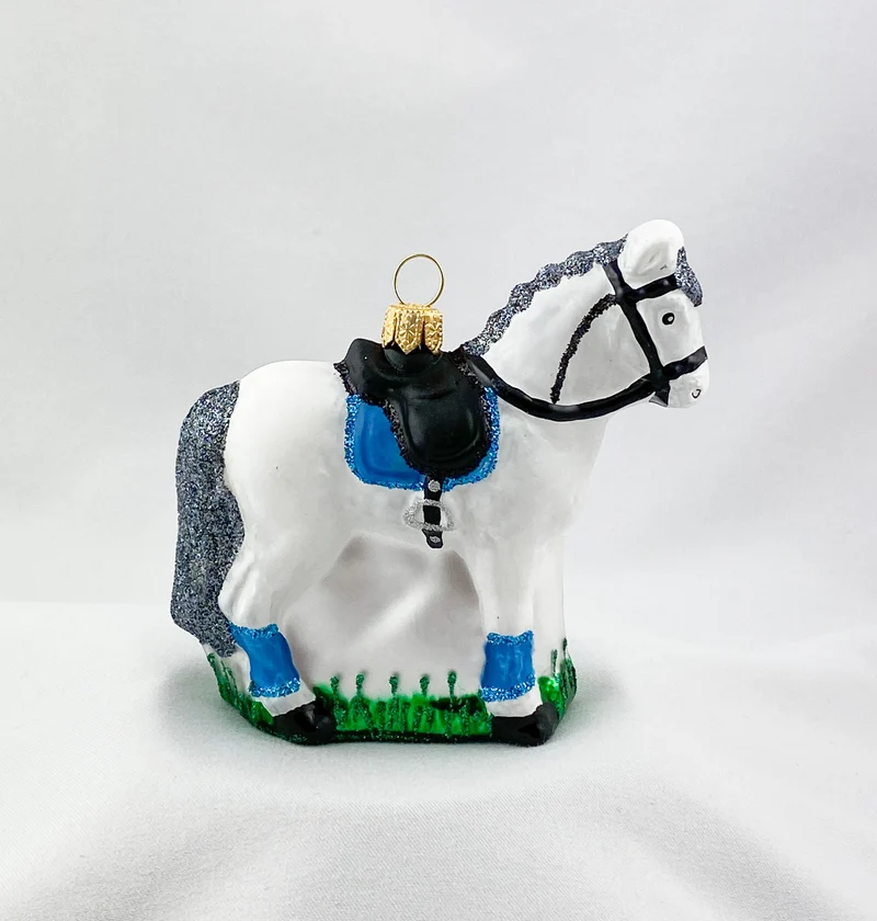 Weisses Pferd mit blauer Satteldecke