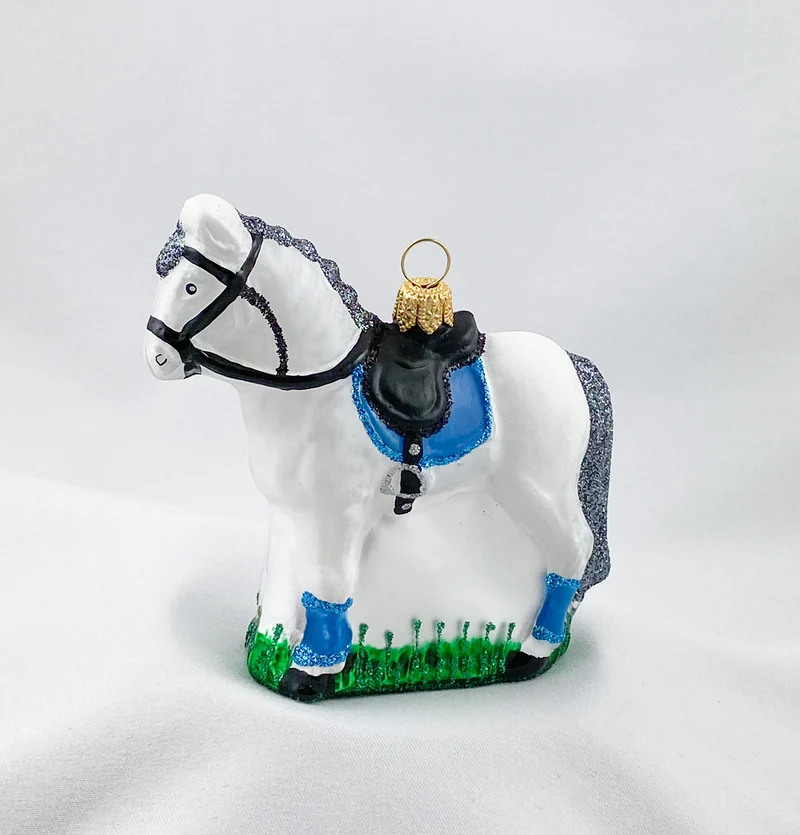 Weisses Pferd mit blauer Satteldecke
