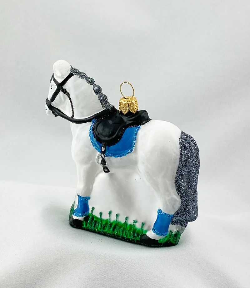 Weisses Pferd mit blauer Satteldecke