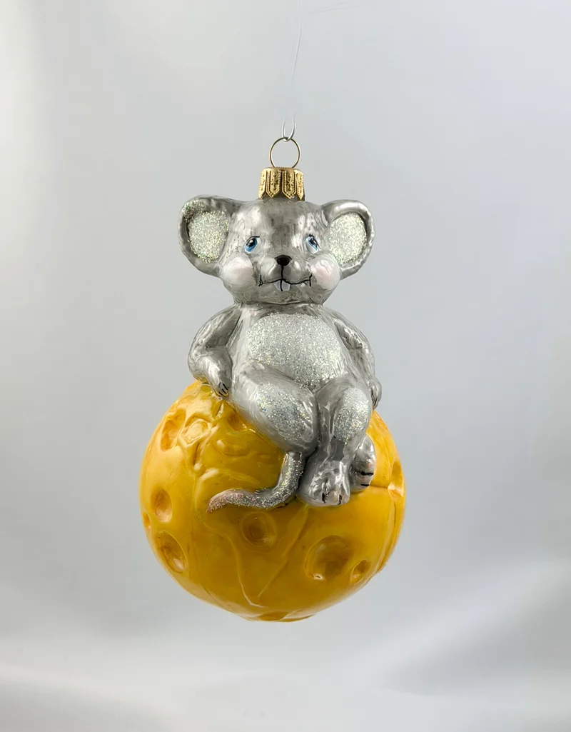 Die Maus sitzt gemütlich auf dem Käse-Globus