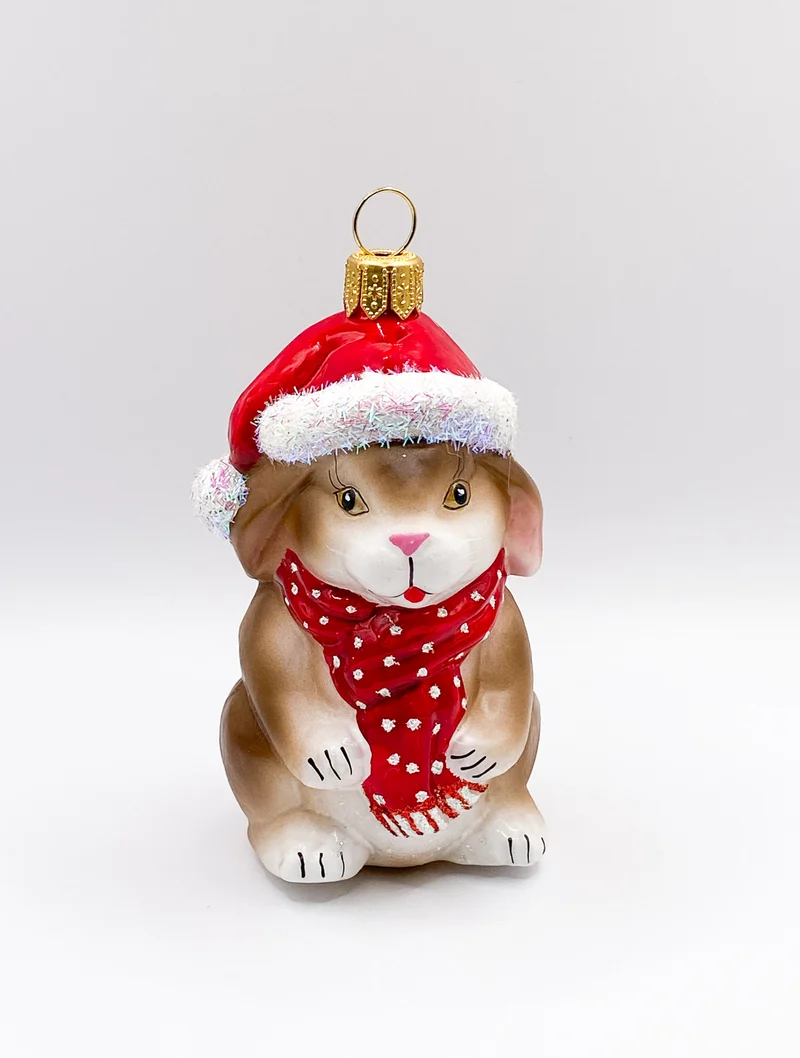 Kleiner braun-weisser Hase mit roter Mütze und Schal