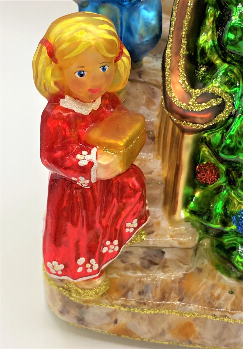 Die Kinder legen die Geschenke unter den Christbaum