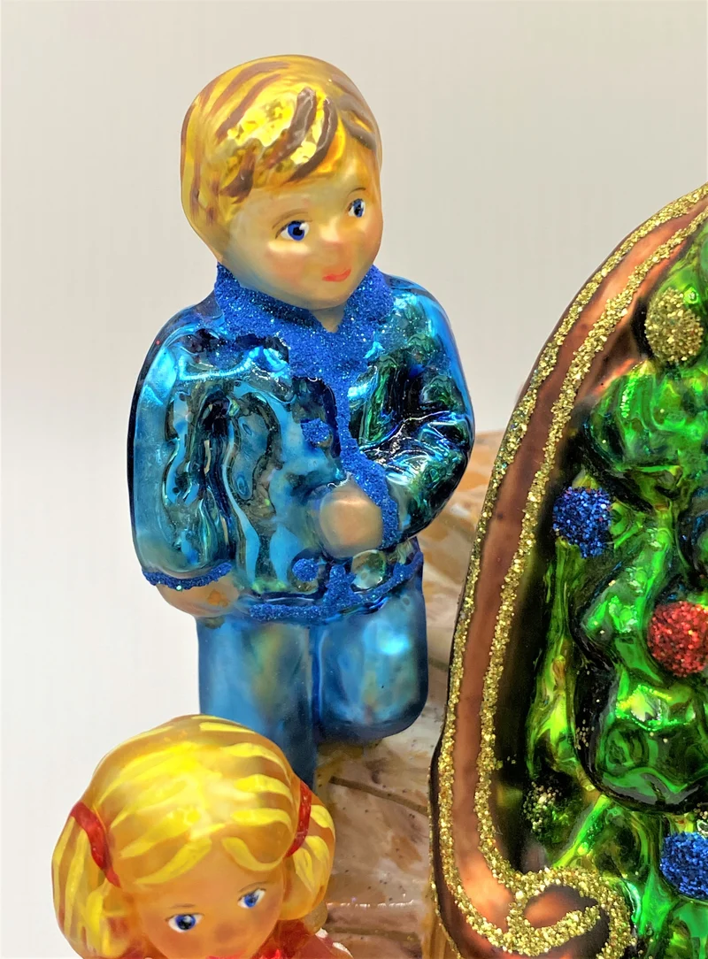 Die Kinder legen die Geschenke unter den Christbaum