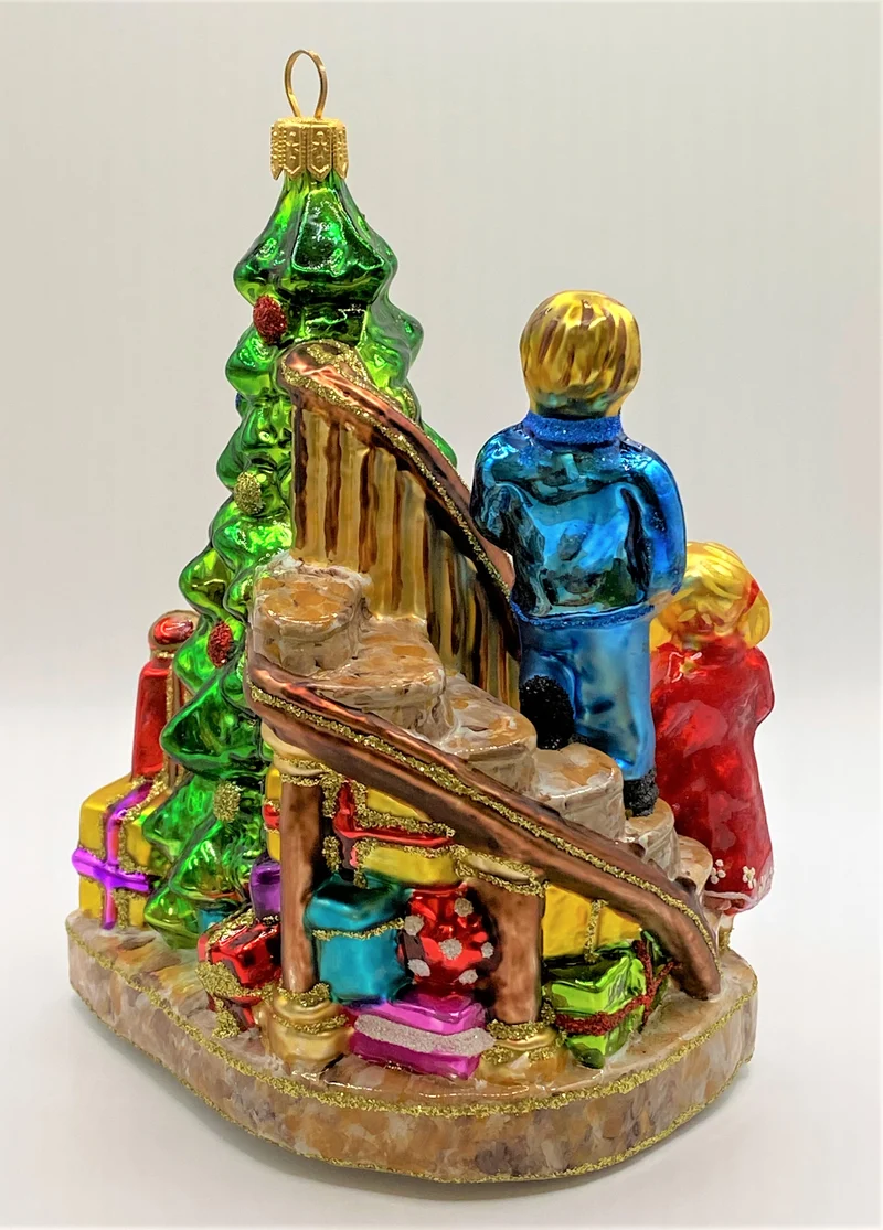 Die Kinder legen die Geschenke unter den Christbaum