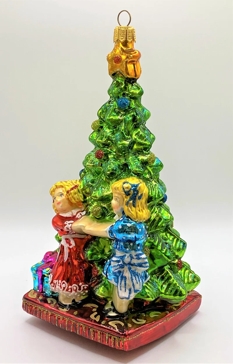 Zwei Mädchen tanzen um den Christbaum