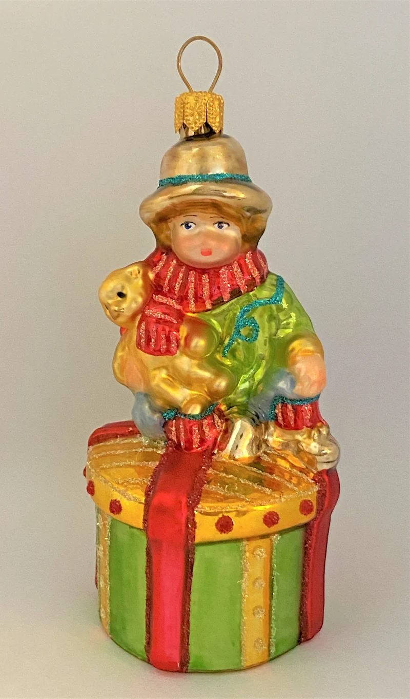 Junge mit Teddybär auf Geschenkpäckli