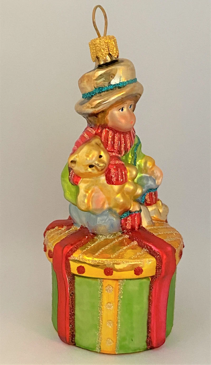 Junge mit Teddybär auf Geschenkpäckli