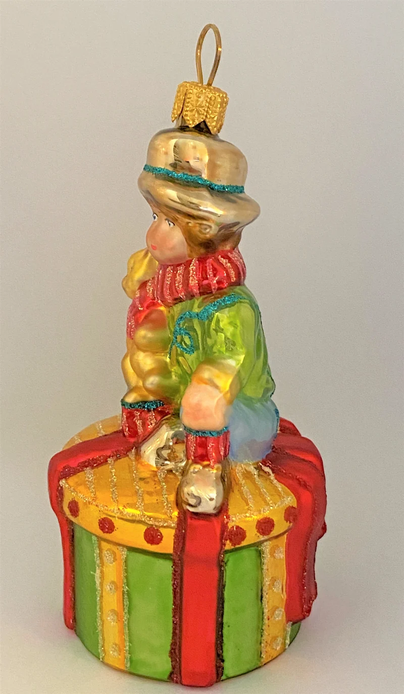 Junge mit Teddybär auf Geschenkpäckli