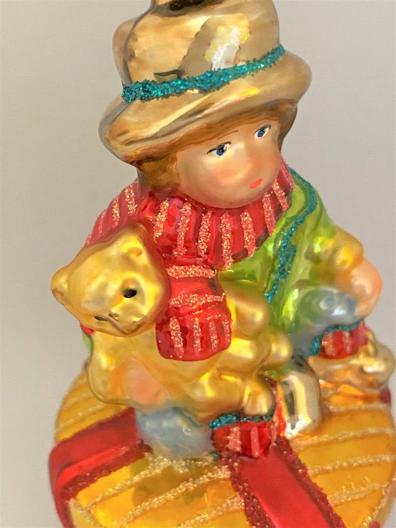 Junge mit Teddybär auf Geschenkpäckli