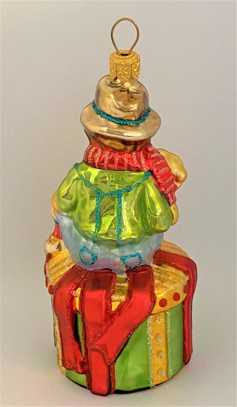 Junge mit Teddybär auf Geschenkpäckli