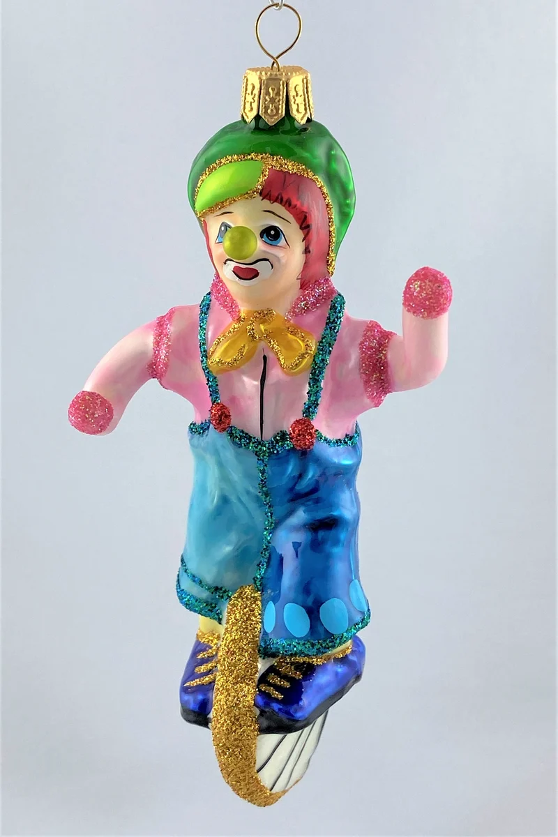 Clown im rosa Hemd fährt Einrad