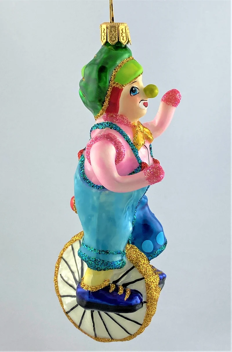 Clown im rosa Hemd fährt Einrad