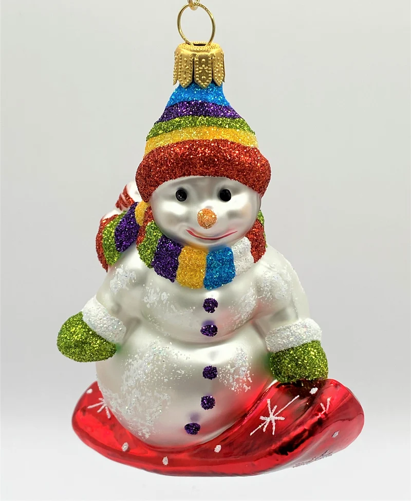 Schneemann mit bunter Mütze auf Snowboard
