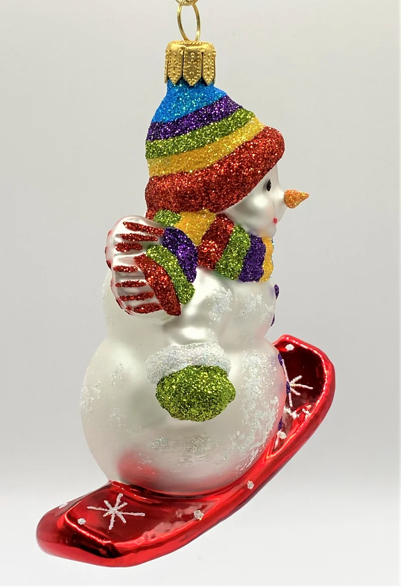 Schneemann mit bunter Mütze auf Snowboard