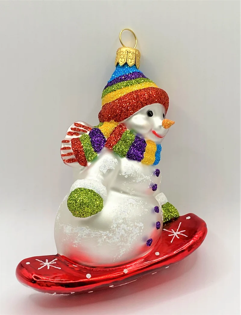 Schneemann mit bunter Mütze auf Snowboard