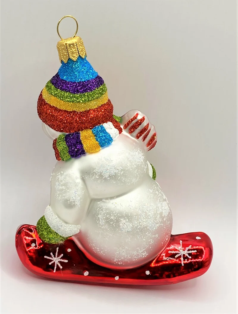 Schneemann mit bunter Mütze auf Snowboard