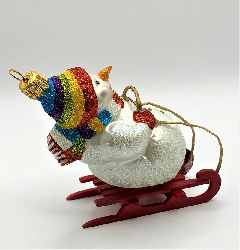 Schneemann mit bunter Mütze auf Schlitten