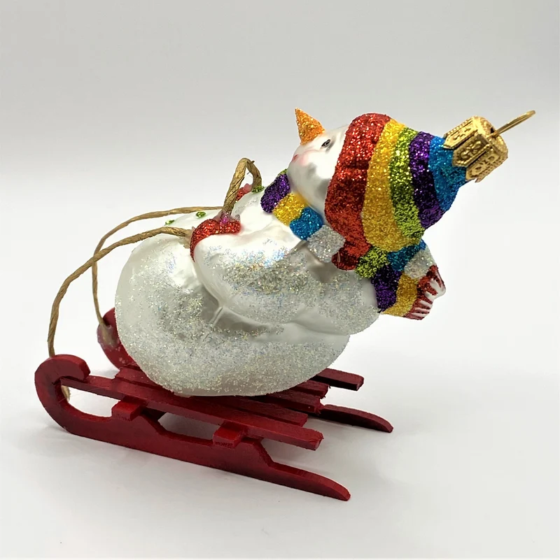 Schneemann mit bunter Mütze auf Schlitten