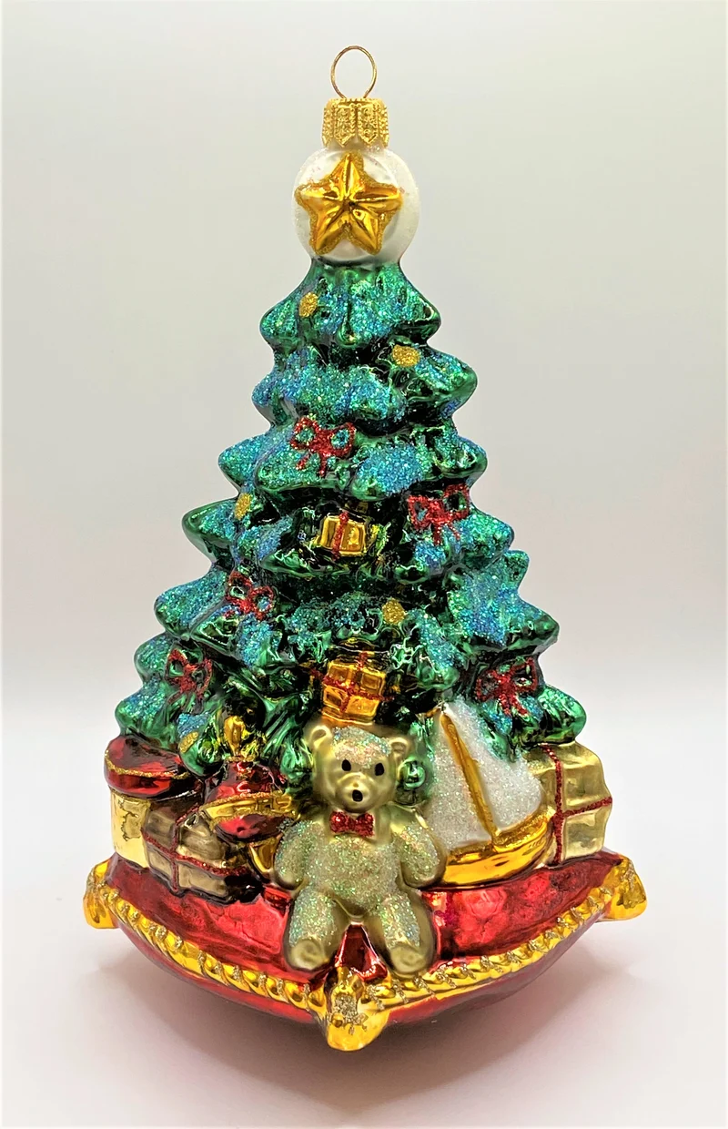 Christbaum mit Teddybär, Lokomotive und Segelboot auf Kissen