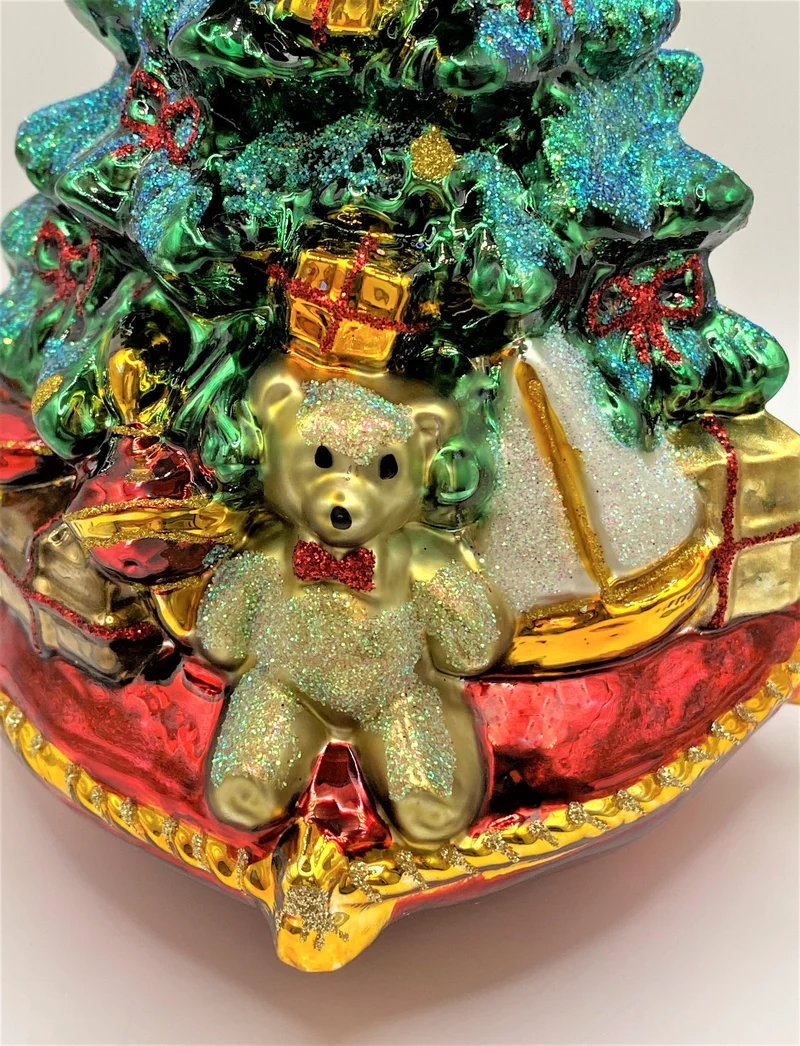 Christbaum mit Teddybär, Lokomotive und Segelboot auf Kissen