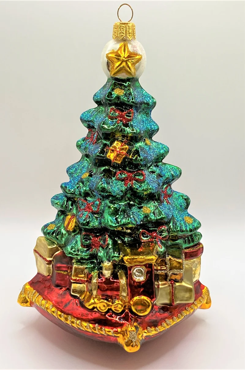 Christbaum mit Teddybär, Lokomotive und Segelboot auf Kissen