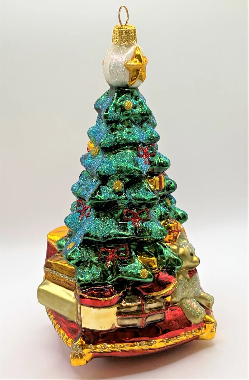 Christbaum mit Teddybär, Lokomotive und Segelboot auf Kissen