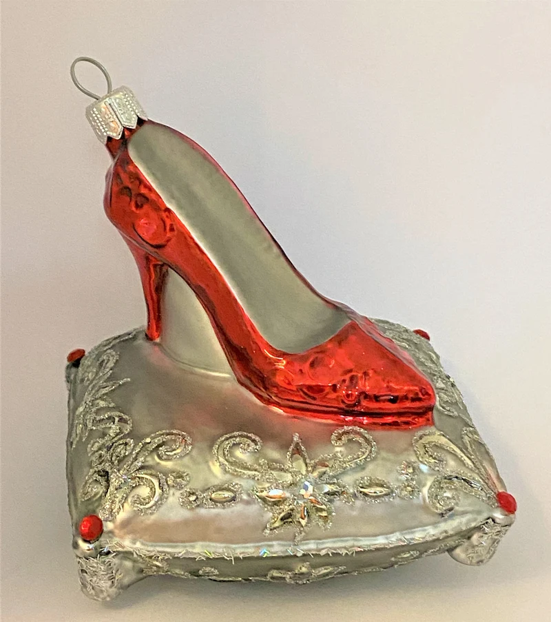 Roter High Heels auf silbernem Brokatkissen
