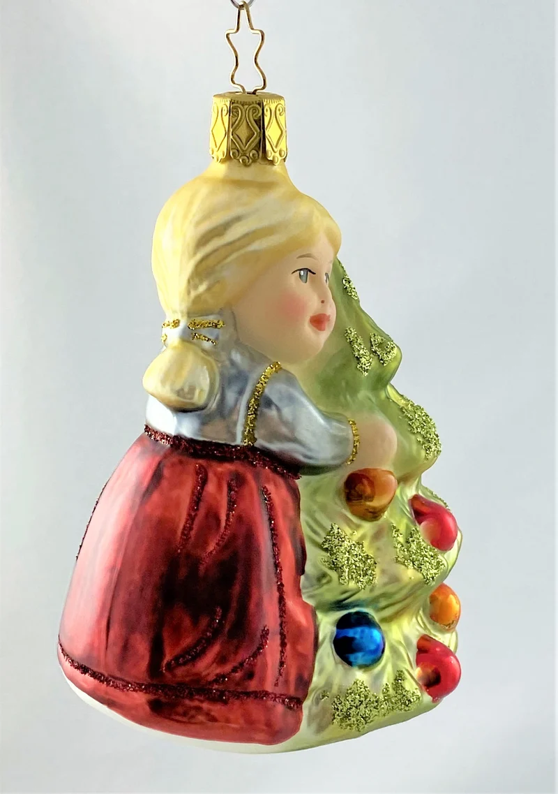 Das kleinen Mädchen umarmt den Christbaum