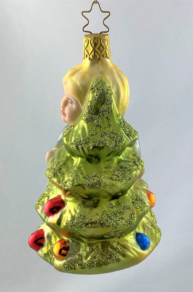 Das kleinen Mädchen umarmt den Christbaum
