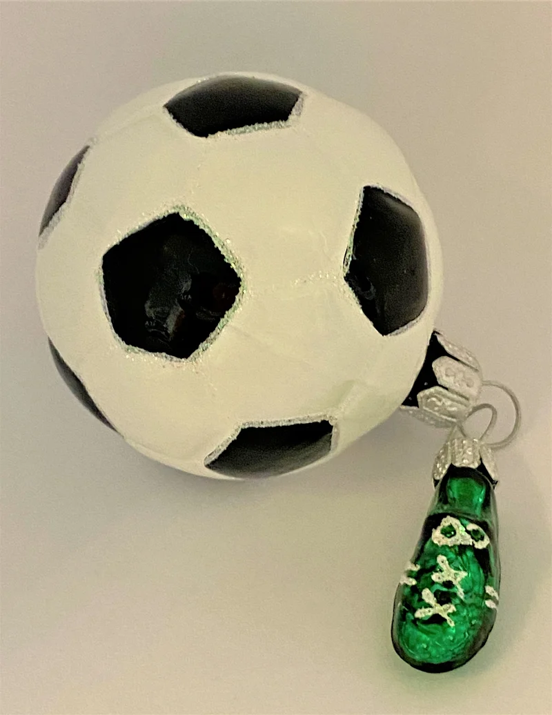 Fussball mit kleinem grünen Fussball-Schuh