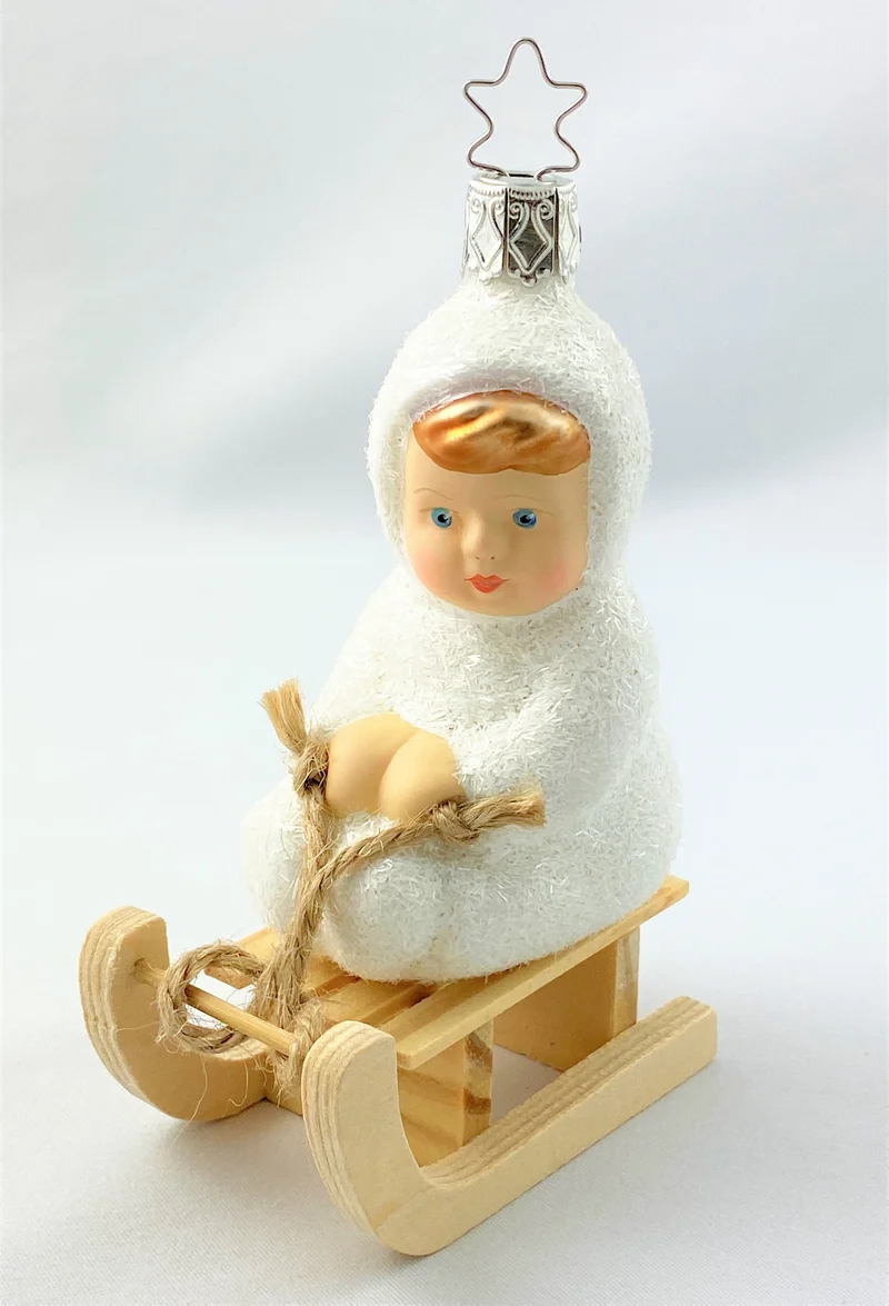 Schneekind fährt auf dem Schlitten