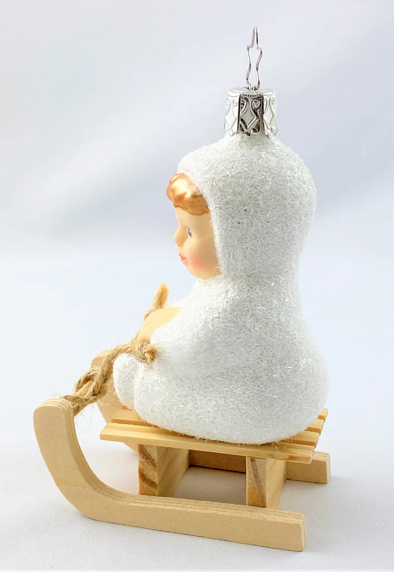 Schneekind fährt auf dem Schlitten