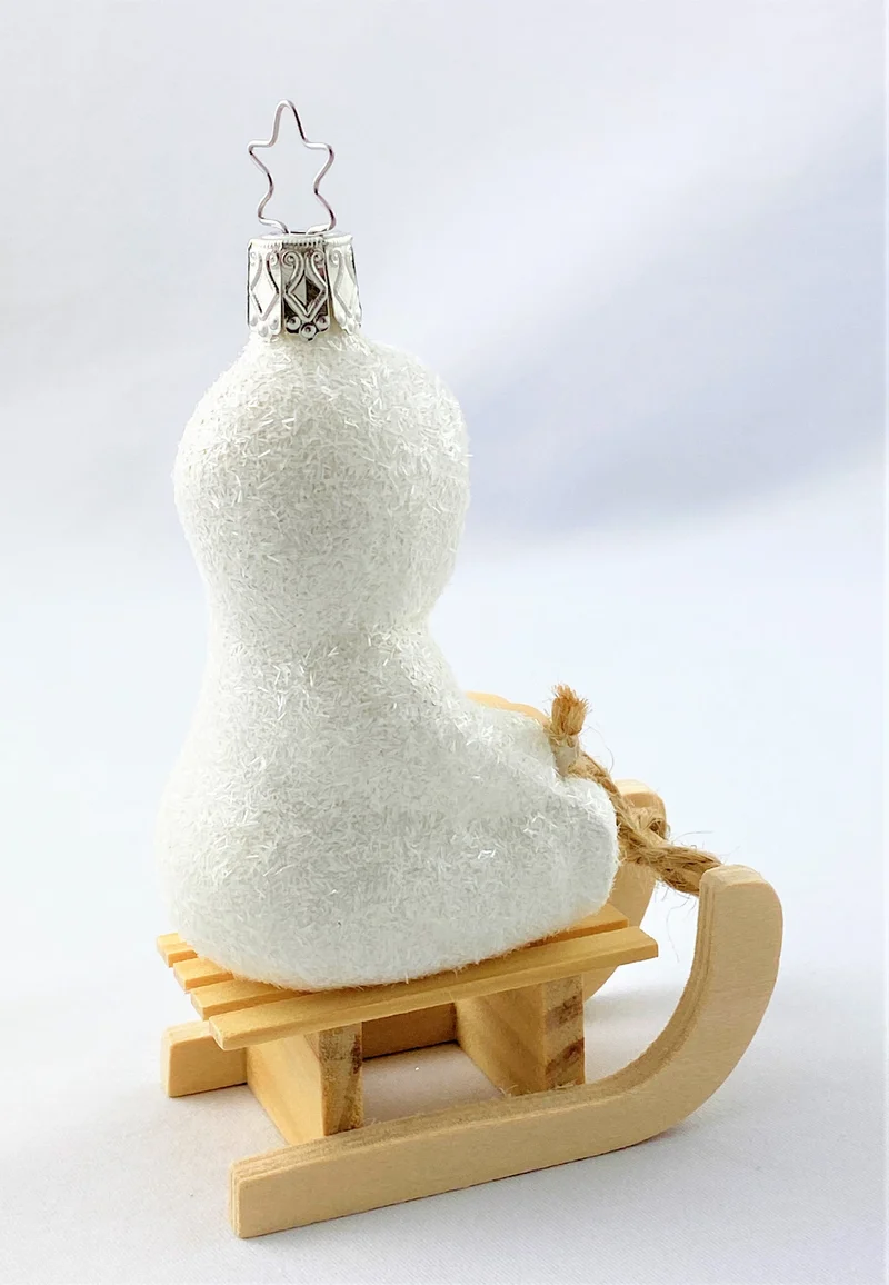 Schneekind fährt auf dem Schlitten