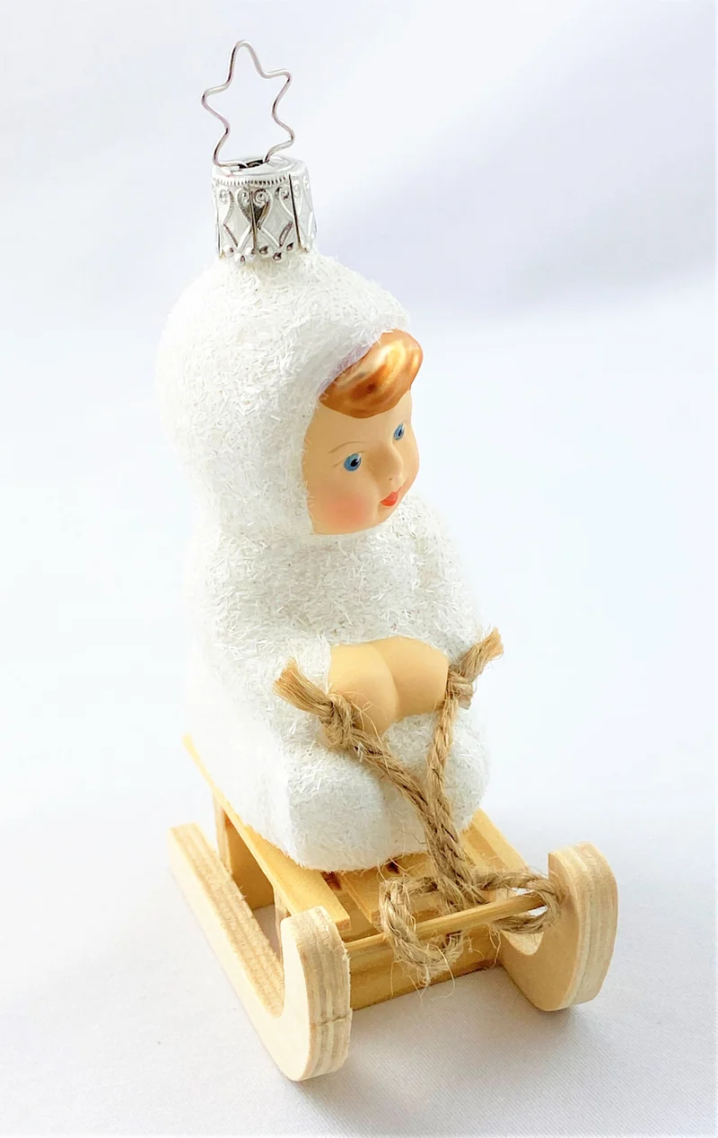 Schneekind fährt auf dem Schlitten