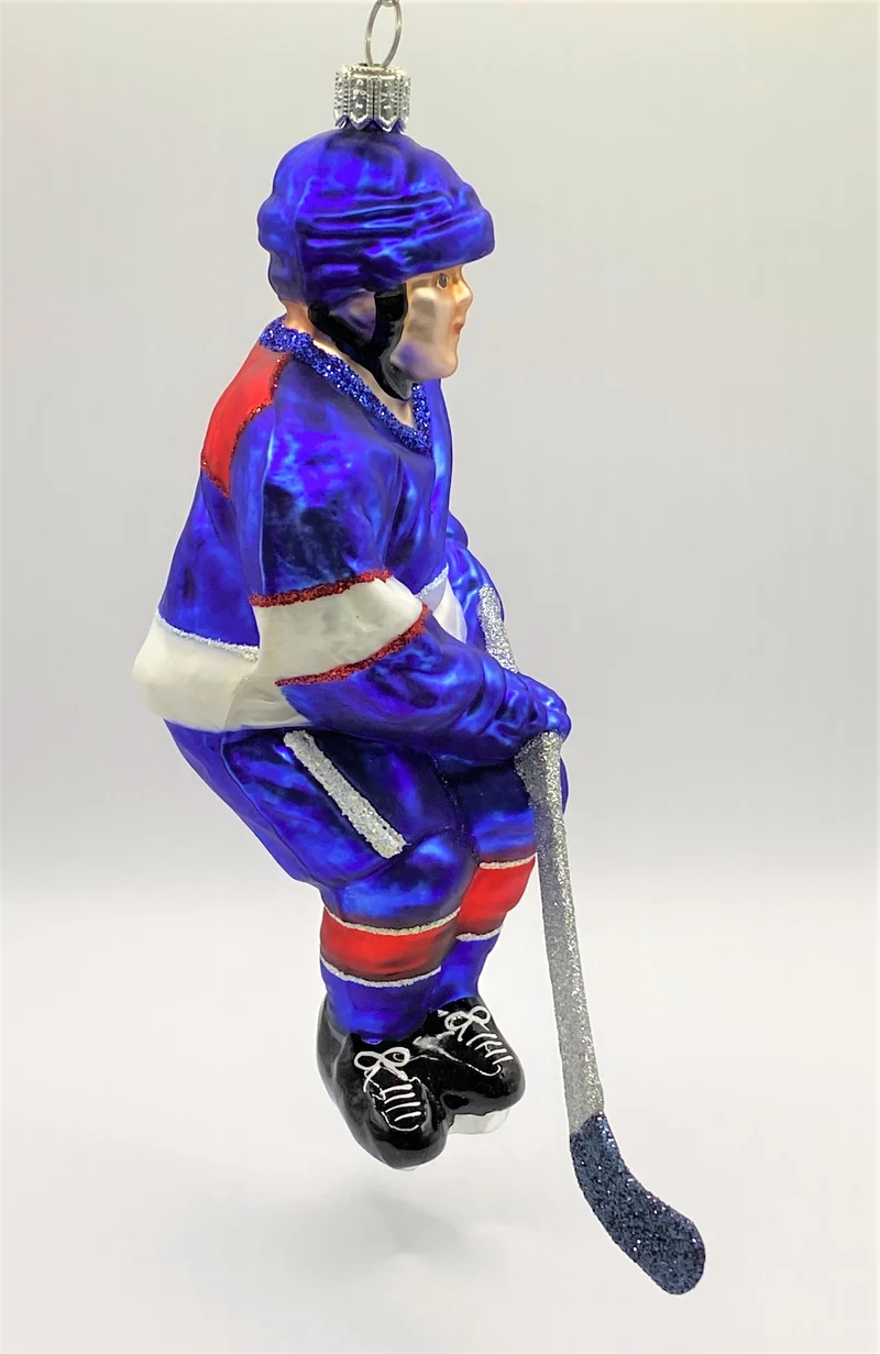 Schweizer Eishockey Spieler in blauem Trikot mit weissen und roten Streifen