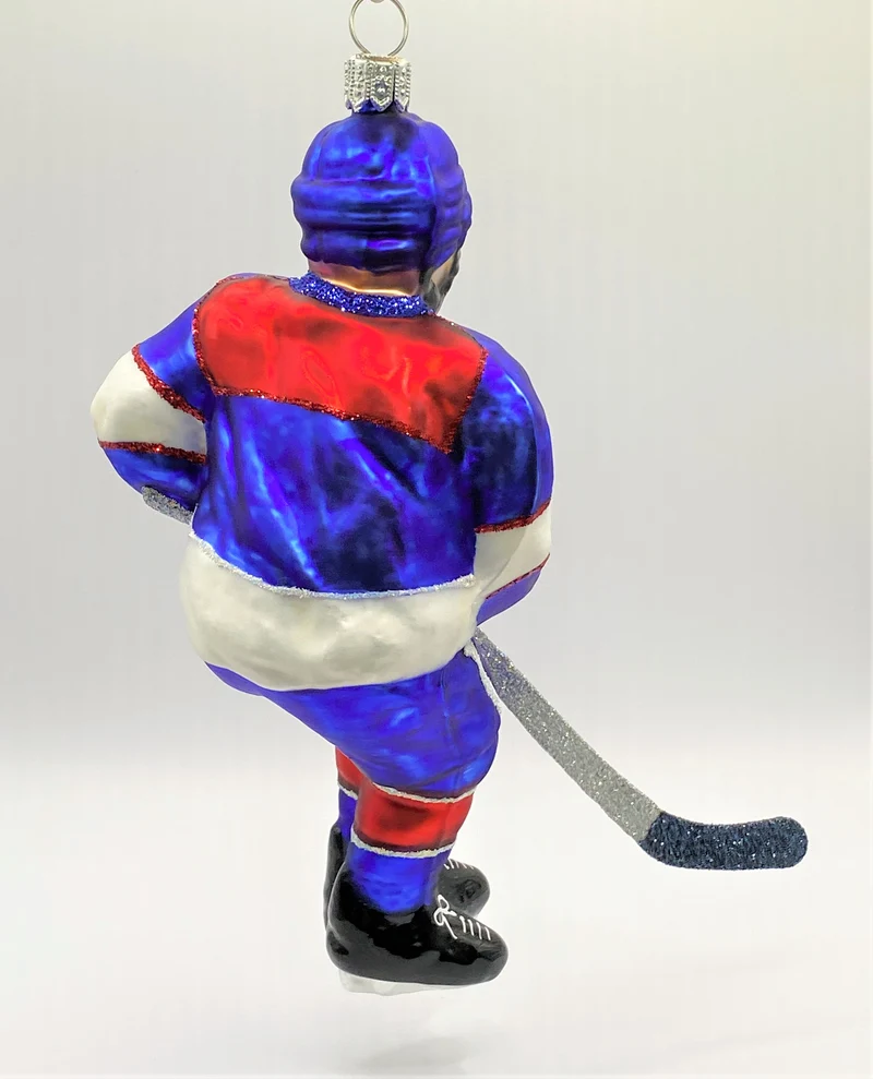 Schweizer Eishockey Spieler in blauem Trikot mit weissen und roten Streifen