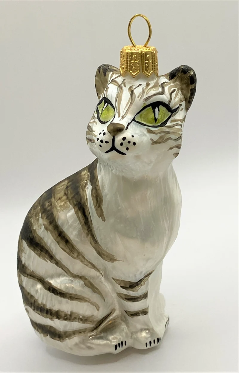 Aufrecht sitzende weisse Tigerkatze mit grünen Augen