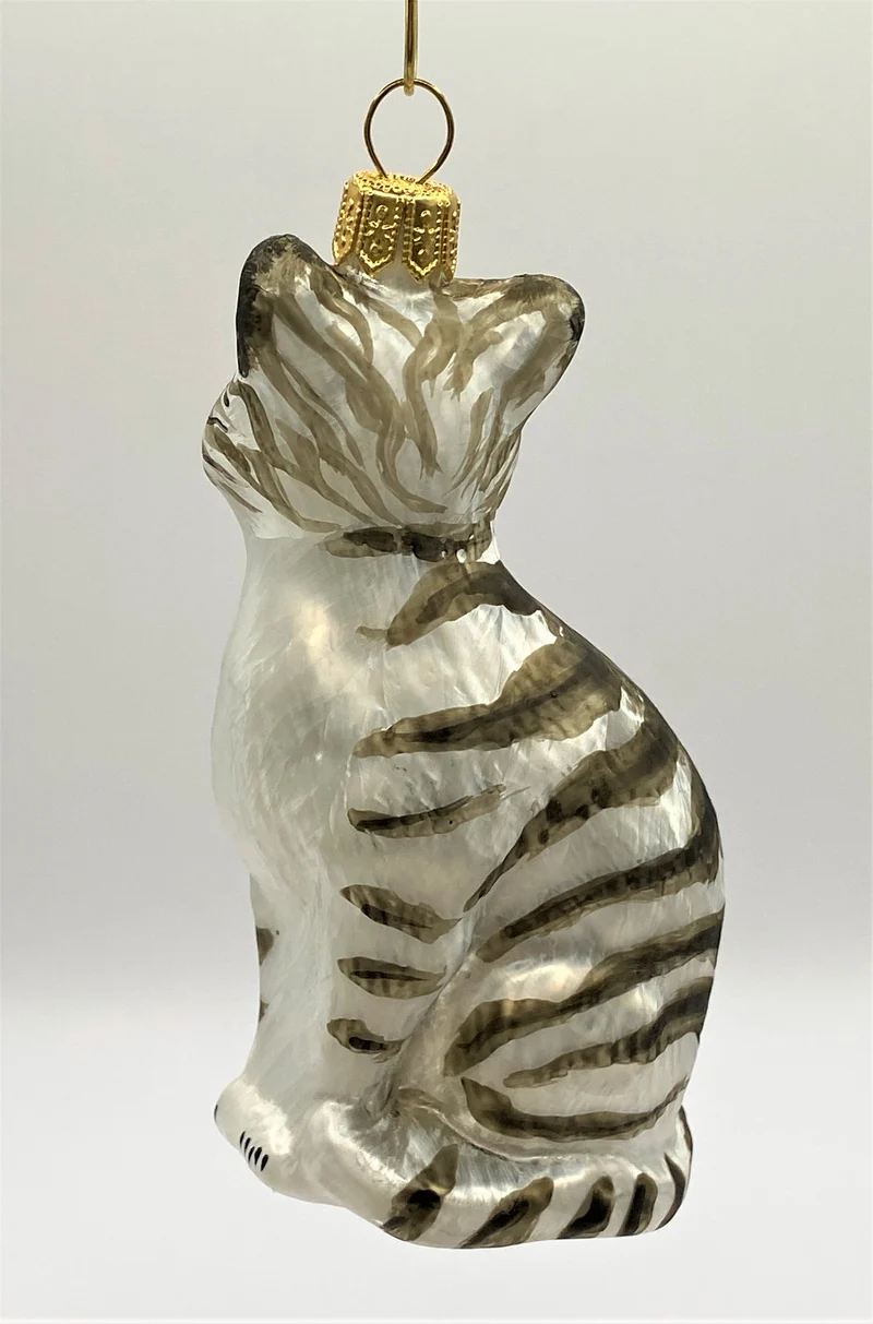 Aufrecht sitzende weisse Tigerkatze mit grünen Augen
