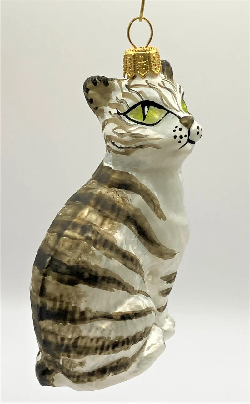 Aufrecht sitzende weisse Tigerkatze mit grünen Augen